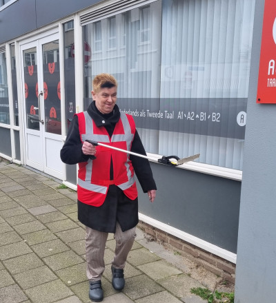 een medewerken van Cyou pakt zwerfvuil op met een grijpstok